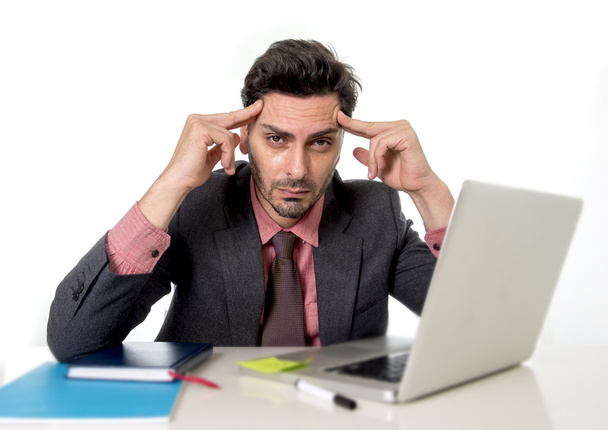 young attractive businessman sitting at office desk working on computer laptop suffering headache - 写真・画像