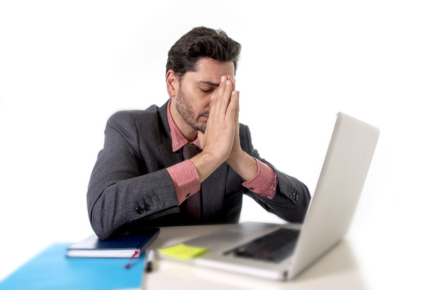 joven hombre de negocios sentado en el escritorio de la oficina trabajando en computadora portátil desesperado preocupado por el estrés laboral
 - Foto, imagen