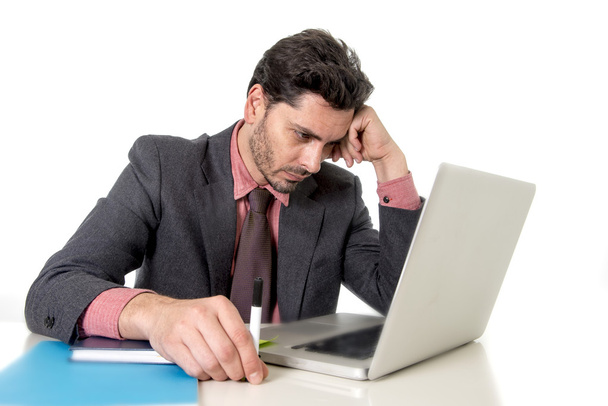 nuori liikemies istuu toimistotiskillä työskentelee tietokoneen kannettava epätoivoinen huolissaan työn stressiä
 - Valokuva, kuva
