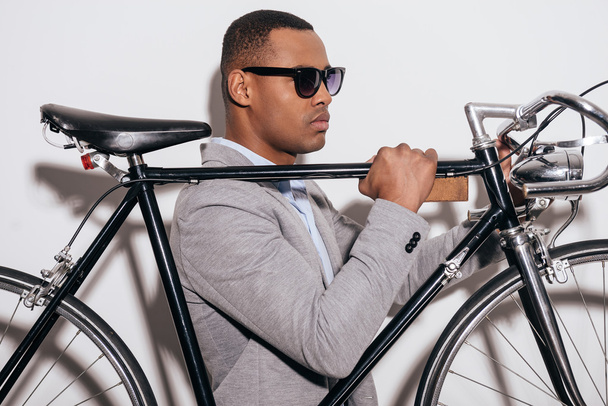 African man in sunglasses carrying bicycle - Foto, Imagem