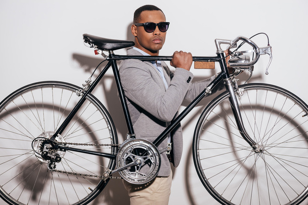 African man in sunglasses carrying bicycle - Foto, afbeelding