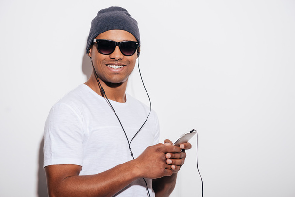 man in headphones holding his smart phone - Foto, Bild