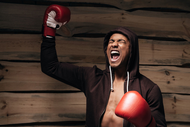 man in hooded shirt and boxing gloves - Photo, Image