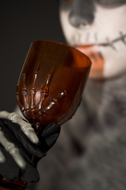 Esqueleto bebiendo de una copa roja
 - Foto, Imagen