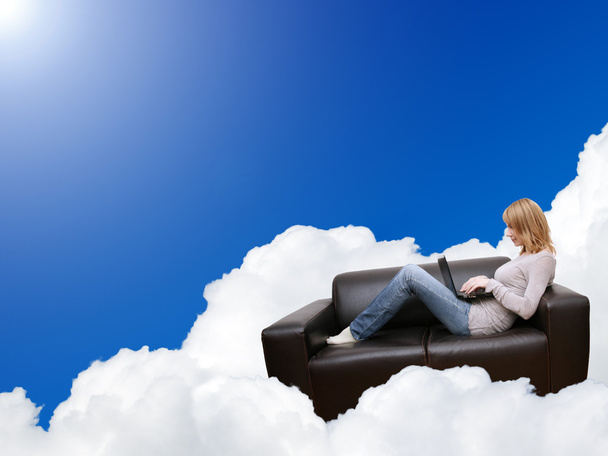 Femme de détente avec ordinateur portable dans le canapé sur le nuage
 - Photo, image