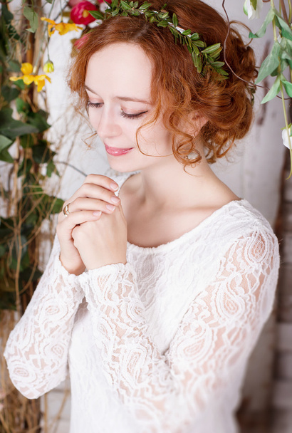 Молодая рыжая невеста в зеленом венке нежно улыбается
 - Фото, изображение