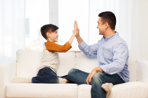 happy father and son doing high five at home - Foto, afbeelding