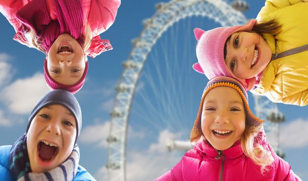 happy little children faces over ferry wheel - Foto, afbeelding