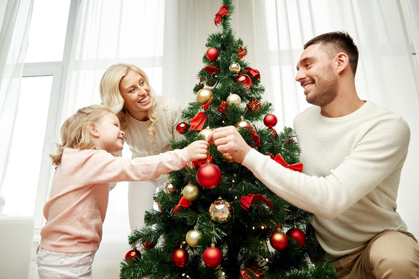 happy family decorating christmas tree at home - Zdjęcie, obraz