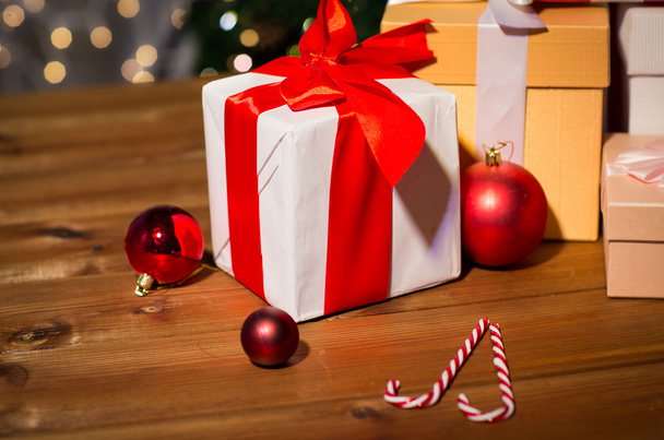 ajándékok, cukorka, és karácsonyi golyókat fából készült táblán - Fotó, kép