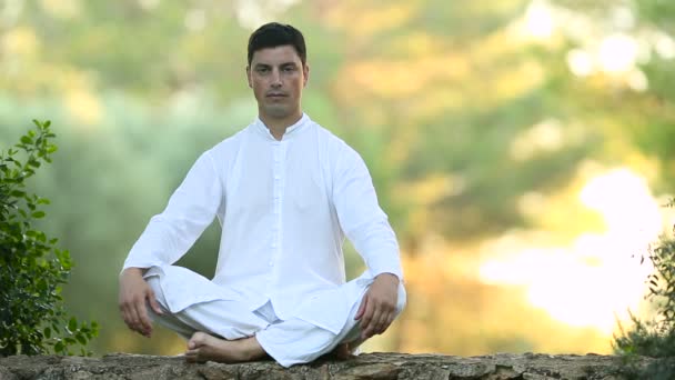 junger lateinischer Mann sitzt auf der Wand und meditiert - Filmmaterial, Video