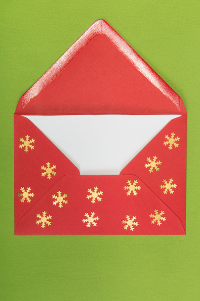 red envelope on green background, christmastime - Foto, afbeelding