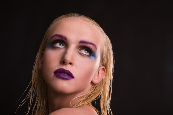 Beautiful model with art makeup on a dark background - Photo, Image