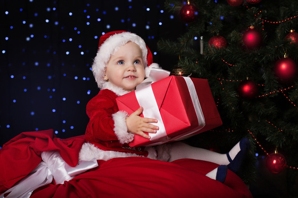 Baby in a Christmas santa costume with gift - Foto, Bild