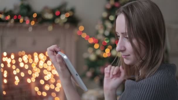 Gelukkige vrouw op zoek in tablet pc voor kerstboom - Video