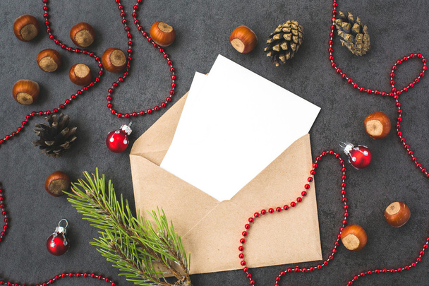 Kirjekuori, käpyjä, hasselpähkinöitä ja joulukoristeita
 - Valokuva, kuva