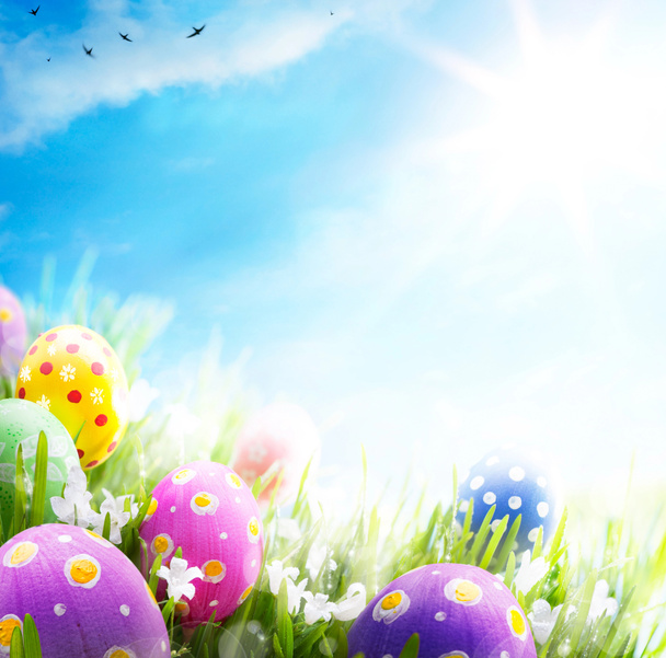 Oeufs de Pâques art décorés de fleurs dans l'herbe sur ciel bleu
 - Photo, image
