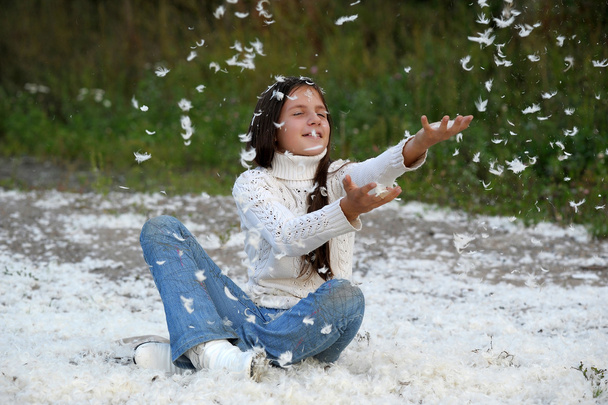 Young beautiful girl filled up by small feathers - Foto, Bild