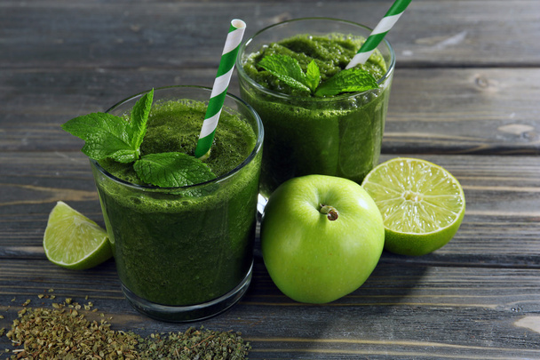 Green healthy juice with fruits and herbs on wooden table close up - Фото, зображення