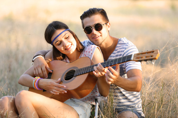 Attractive couple playing guitar - Φωτογραφία, εικόνα