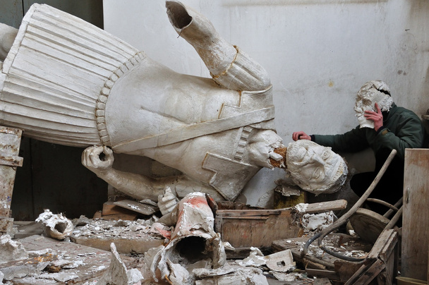 Сломанная статуя и человек с фрагментом гипсовой маски
 - Фото, изображение