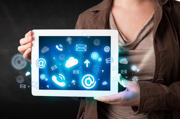Persona sosteniendo una tableta con iconos y símbolos de tecnología azul - Foto, imagen