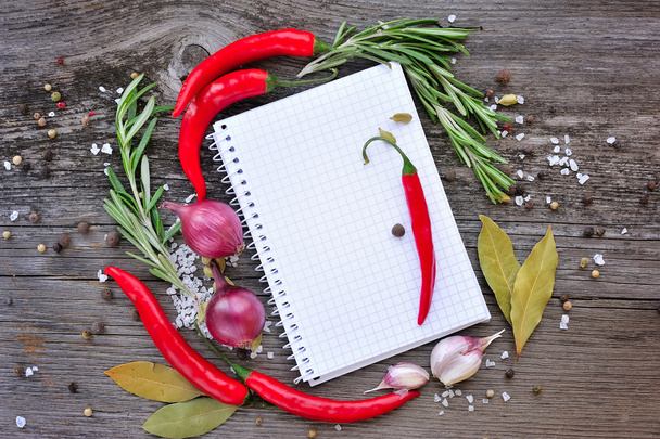 Verduras y condimentos con cuaderno abierto para recetas sobre fondo de madera
 - Foto, imagen