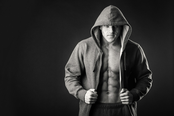 Svalnatý muž v sportovní bunda na tmavém pozadí - Fotografie, Obrázek