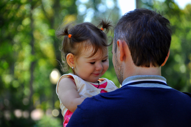Маленька дочка його батька на руках
 - Фото, зображення