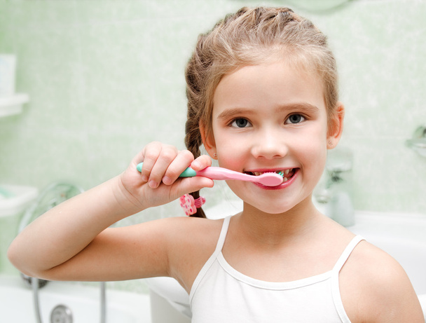 Smiling cute little girl brushing teeth  - Photo, Image