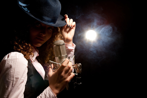 Beautiful singer in hat with microphone - Фото, изображение