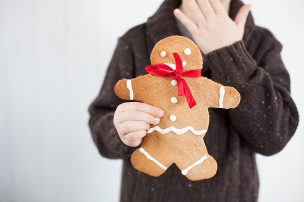 child holding Gingerbread man - boy biting gingerbread people - Фото, зображення