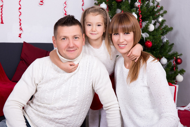 familia joven frente al árbol de Navidad
 - Foto, Imagen
