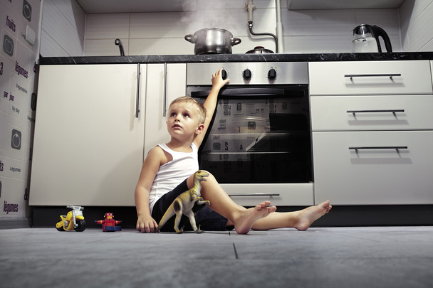 Kind spielt in der Küche mit Gasherd. - Foto, Bild