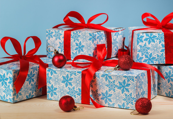 Cadeau dans un beau paquet avec un ruban rouge sur fond bleu
 - Photo, image