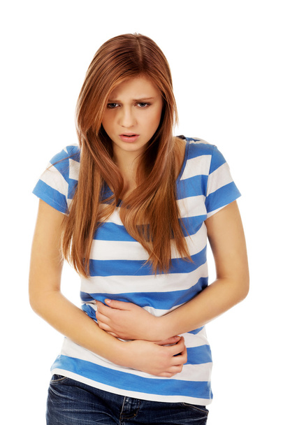 Teenage woman with stomach ache - Foto, afbeelding