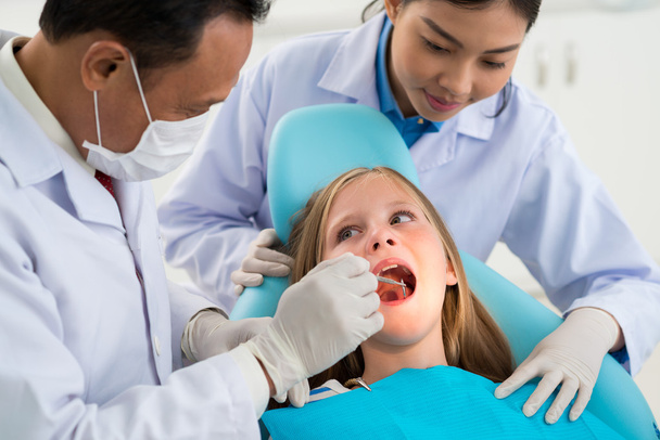 Lääkäri tarkistaa hampaat vähän potilas
 - Valokuva, kuva