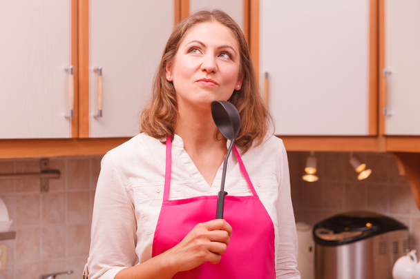 Housewife with ladle in kitchen - 写真・画像