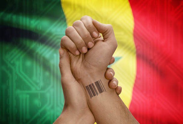 Barcode ID number on wrist of dark skinned person and national flag on background - Senegal - Fotoğraf, Görsel