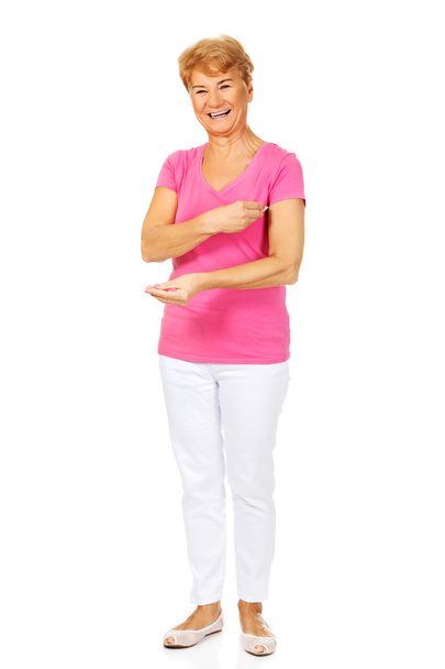 Smiling senior woman holding thermometer - Fotó, kép