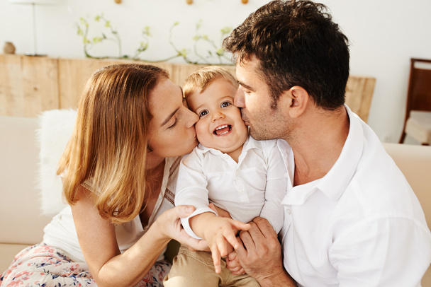 Genitori baciare il loro piccolo figlio
 - Foto, immagini