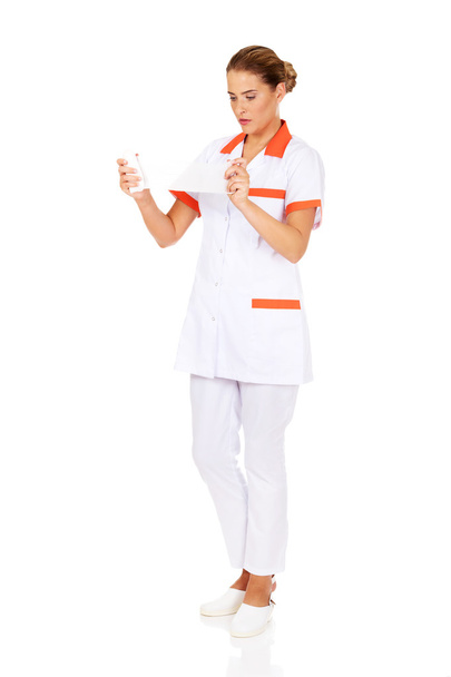 Young female nurse or doctor holding a bandage - Фото, изображение