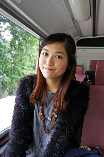 Mujer asiática en el autobús y sonriendo
 - Foto, imagen