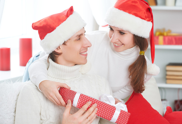 Um presente de Natal. mulher dá um homem presente caixa
  - Foto, Imagem