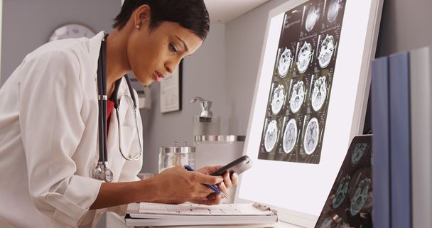 Jeune médecin attrayant textos résultats des scans cérébraux
 - Photo, image