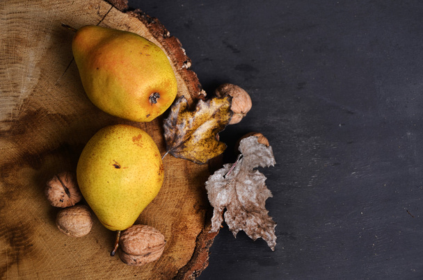 pear and nuts on black background - Фото, зображення