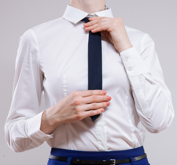 businesswoman sets the necktie - Фото, изображение