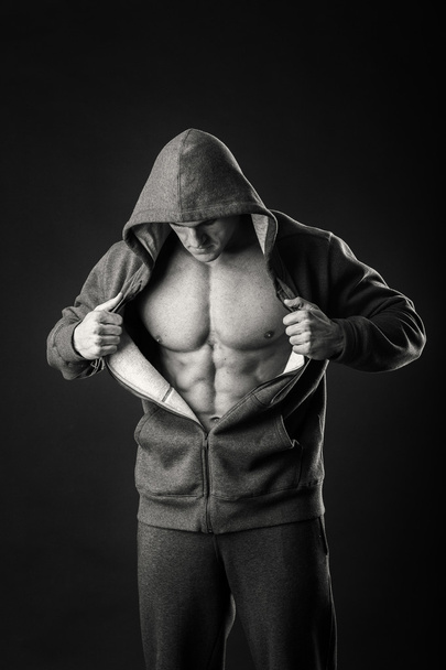 Karanlık bir arka plan üzerinde bir spor ceketli kaslı adamı - Fotoğraf, Görsel