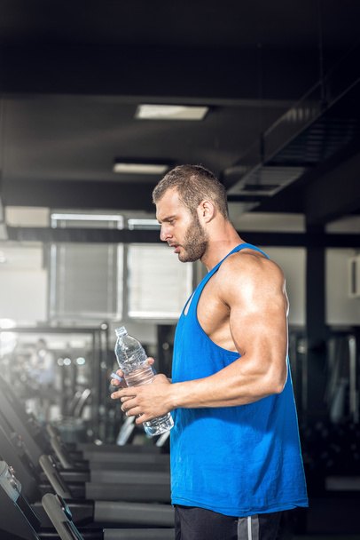 Young man drinking water in gym - Foto, Imagen