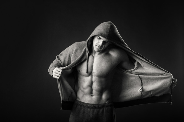 muskulöser Mann in Sportjacke vor dunklem Hintergrund - Foto, Bild